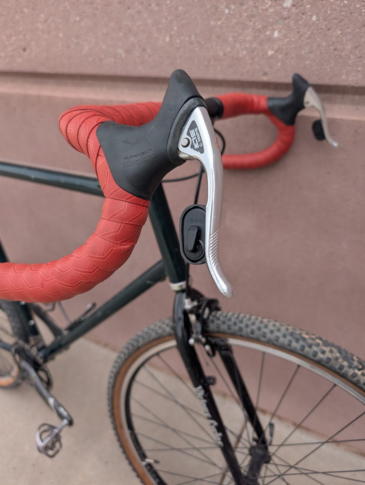 Close-up of the 3D-printed Blip button holder mounted on the brake lever